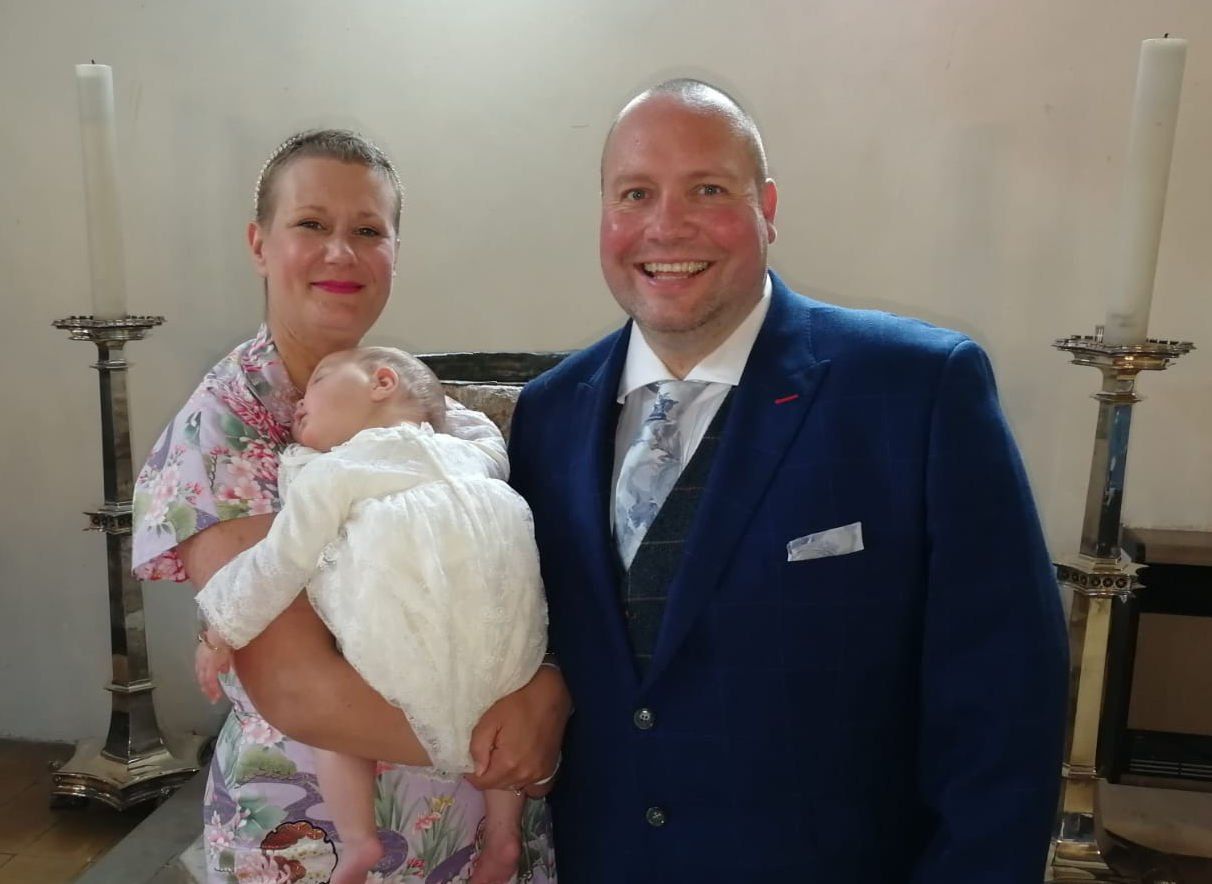 A mother holding her baby in a sunlit hospital room